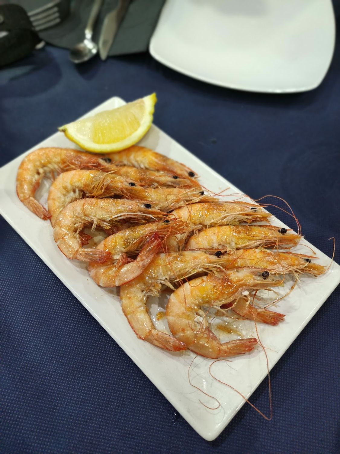 Ración de langostinos a la plancha con limón